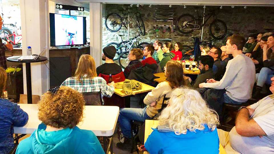 Des gens écoutent un événement de cyclisme au Café-Vélo des Nations